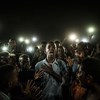 Jovem iluminado por telemóveis recita poesia de protesto. Veja a foto vencedora do ano do World Press Photo