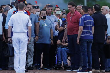 Jair Bolsonaro volta a violar e a criticar isolamento e abraça apoiantes na rua