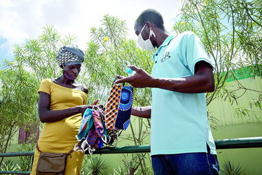 Angolanos improvisam máscaras de pano africano