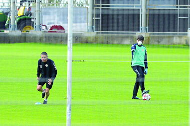 Sob orientação de elementos da equipa técnica (com máscara), jogadores do Nacional voltaram aos treinos de relva 
