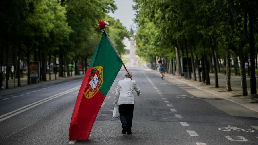 Homem desfila sozinho na Avenida da Liberdade com bandeira de Portugal para assinalar o 25 de Abril