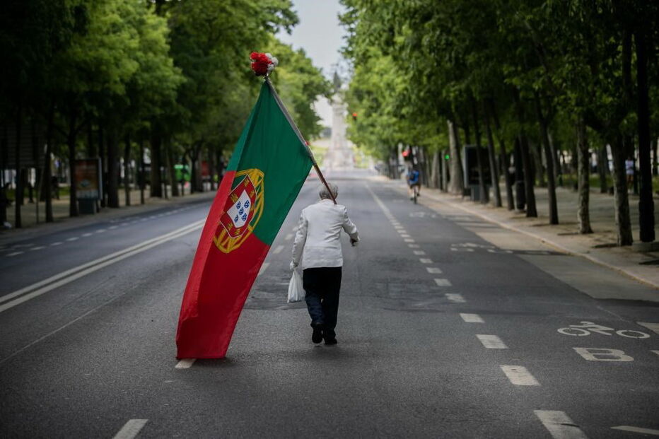 Homem desfila sozinho na Avenida da Liberdade com bandeira de Portugal para assinalar o 25 de Abril