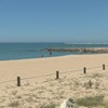 Areal da praia de Quarteira quase vazio em dia de calor. População aproveita paredão para caminhar