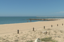 Areal da praia de Quarteira quase vazio em dia de calor. População aproveita paredão para caminhar