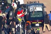 Manifestantes revoltados com morte de George Floyd às mãos das autoridades vandalizam carros da polícia