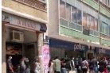 Longa fila de pessoas à entrada do centro comercial Babilónia na Amadora. Veja as imagens