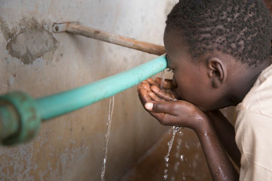 Criança bebe água numa escola em África