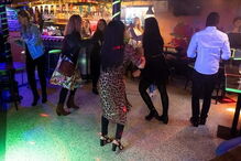 Grupo de pessoas diverte-se a dançar em bar na Islândia