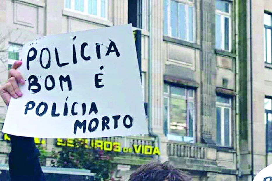 Manifestante mostra cartaz com o dizer “polícia bom é polícia morto”
