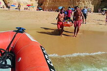Banhista parte pernas a mergulhar de rocha em praia de Lagoa