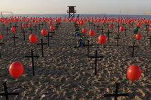 Cruzes negras na praia de Copacabana homenageiam as 100 mil vítimas mortais do coronavírus no Brasil