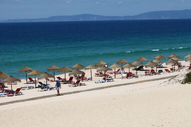 Zona de espreguiçadeiras e chapéus-de-sol no areal da Praia do Pego, no Carvalhal, Comporta.
