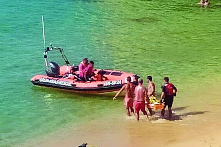 Banhista parte pernas a mergulhar de rocha em praia de Lagoa