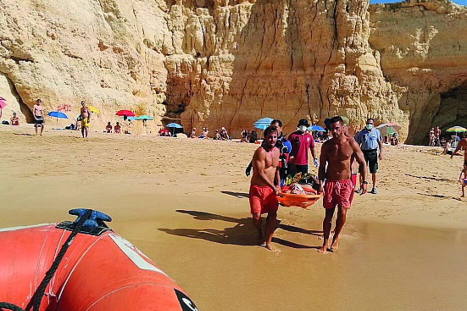 Banhista parte pernas a mergulhar de rocha em praia de Lagoa
