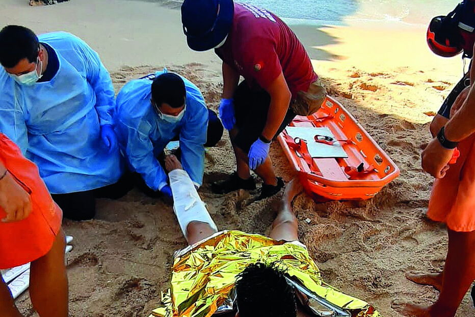 Banhista parte pernas a mergulhar de rocha em praia de Lagoa