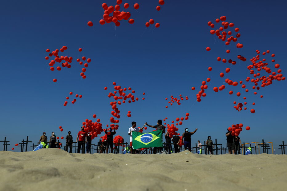 Cruzes negras na praia de Copacabana homenageiam as 100 mil vítimas mortais do coronavírus no Brasil