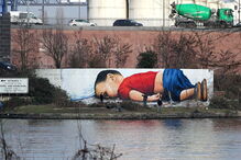Um graffiti dos artistas Justus Becker e Oguz Sen retrata o menino refugiado sírio Alan Kurdi 