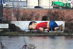 Um graffiti dos artistas Justus Becker e Oguz Sen retrata o menino refugiado sírio Alan Kurdi 