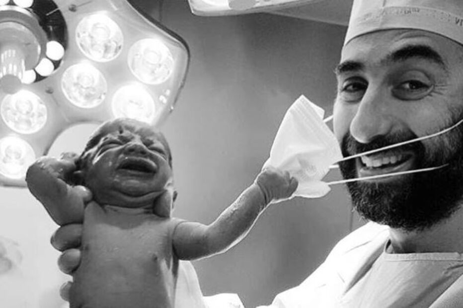Recém-nascido puxa a máscara ao obstetra momentos após o parto 