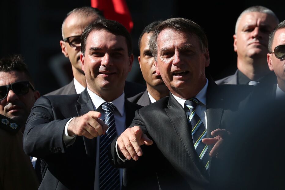 Flávio Bolsonaro (à esquerda) é acusado de ter criado um esquema criminoso quando era deputado regional no Rio de Janeiro