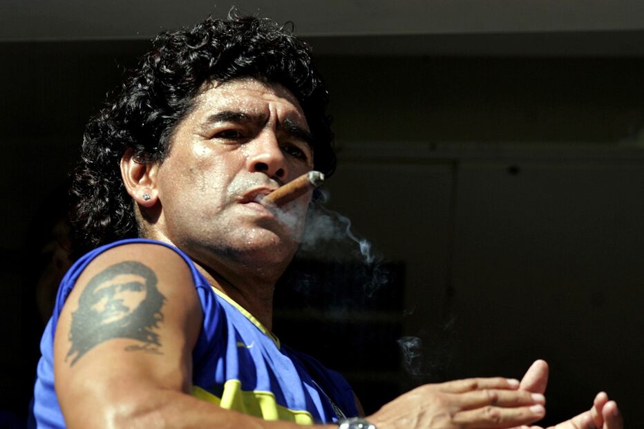 Futebolista argentino Maradona fuma um charuto antes do início de uma partida de futebol em Buenos Aires