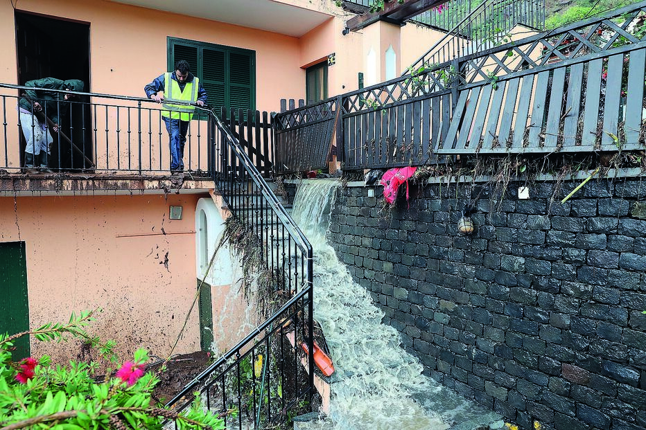 Moradores procuram salvar a habitação já com vários estragos provocados pelas enxurradas
