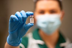 Profissional de saúde segura dose da vacina da Pfizer e BioNTech