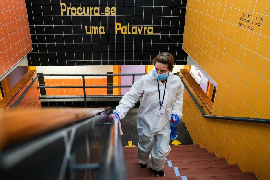 Assistente desinfeta corrimões das escadas