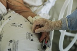Um elemento da equipa médica cuida de um paciente hospitalizado na Unidade de Cuidados Intensivos covid-19 do Hospital Santa Maria