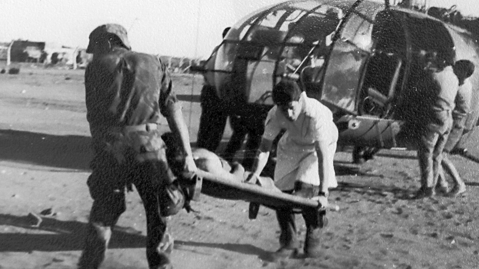 Transporte de um ferido em maca do helicóptero  que o retirou do mato para a enfermaria, onde o médico Américo Dinis da Gama o  esperava para a intervenção necessária 