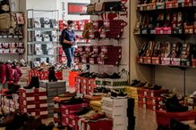 Uma funcionária da Sapataria Bruna arruma o espaço comercial, na baixa de Faro, 15 de abril de 2021. O comércio local na baixa de Faro procura resistir às restrições impostas pelo combate à pandemia de covid-19