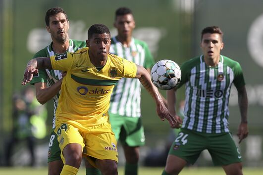 Douglas Tanque protege a bola perante a pressão de Tarantino e o olhar atento de outros jogadores do Rio Ave