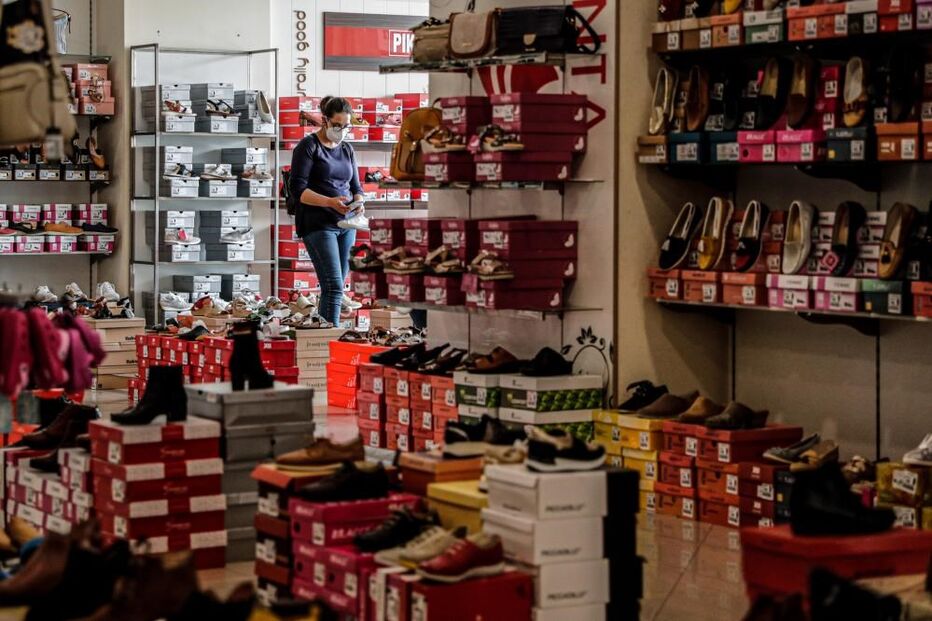 Uma funcionária da Sapataria Bruna arruma o espaço comercial, na baixa de Faro, 15 de abril de 2021. O comércio local na baixa de Faro procura resistir às restrições impostas pelo combate à pandemia de covid-19