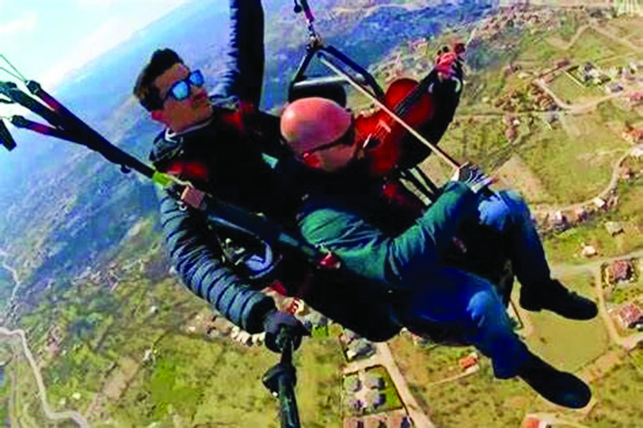 Homem com medo de alturas toca violino durante passeio de parapente