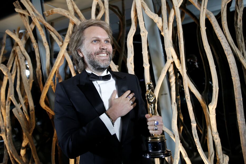 Florian Zeller sorri enquanto segura o Óscar para Melhor Argumento Adaptado com o filme