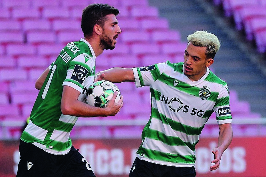 Pote apressa colega Paulinho para o jogo recomeçar, após um golo