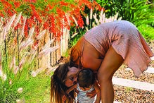 A atriz com o filho mais novo no jardim da nova casa