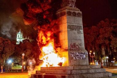 Estátua de Pedro Álvares Cabral incendiada e vandalizada no Rio de Janeiro durante protestos de movimento indígena