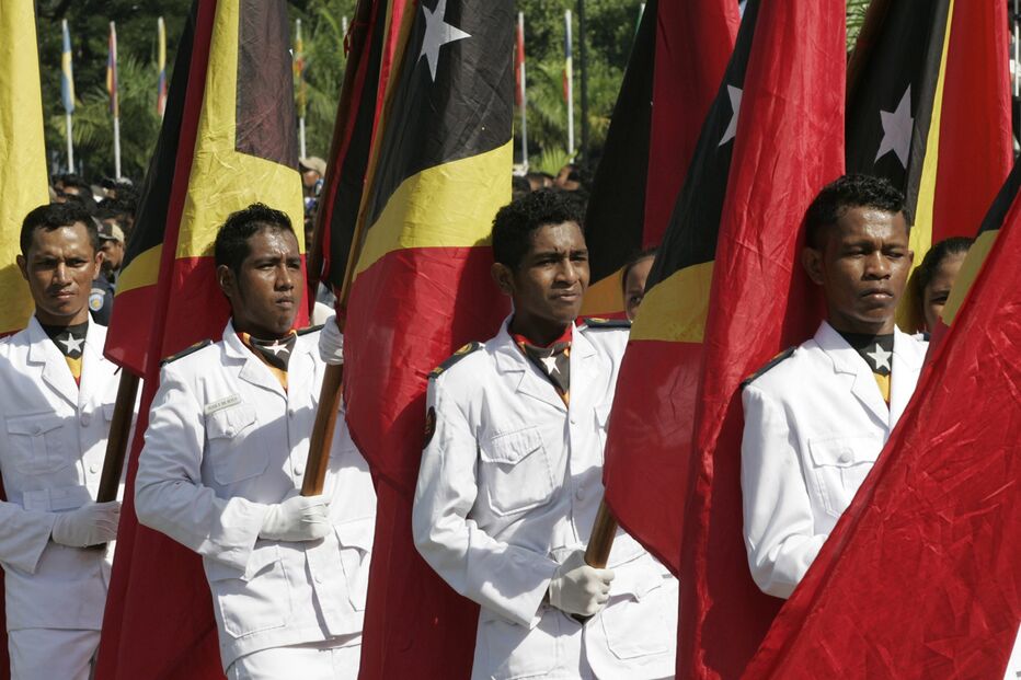 Estudantes em Timor-Leste carregam bandeiras na comemoração do indpendência do país, 2009