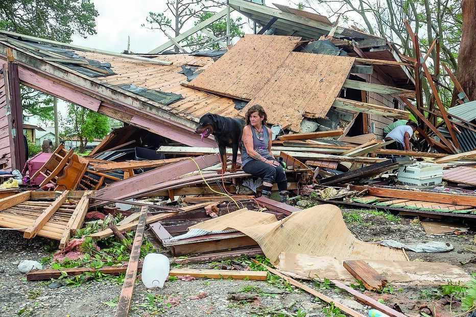 Uma mulher e o seu cão nos escombros da sua casa em Houma, no estado da Luisiana