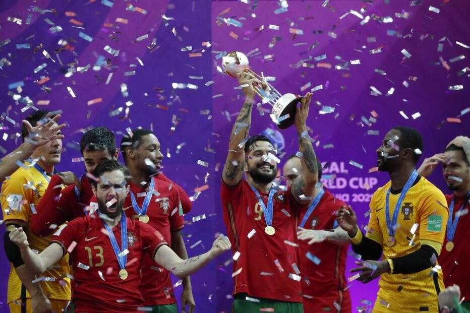 Jogadores de Portugal celebram com o troféu após a vitória do Mundial de Futsal