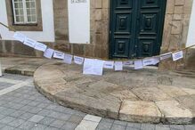 Grupo de bombeiros coloca uma mangueira, com mensagens para a população