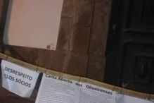 Grupo de bombeiros coloca uma mangueira, com mensagens para a população