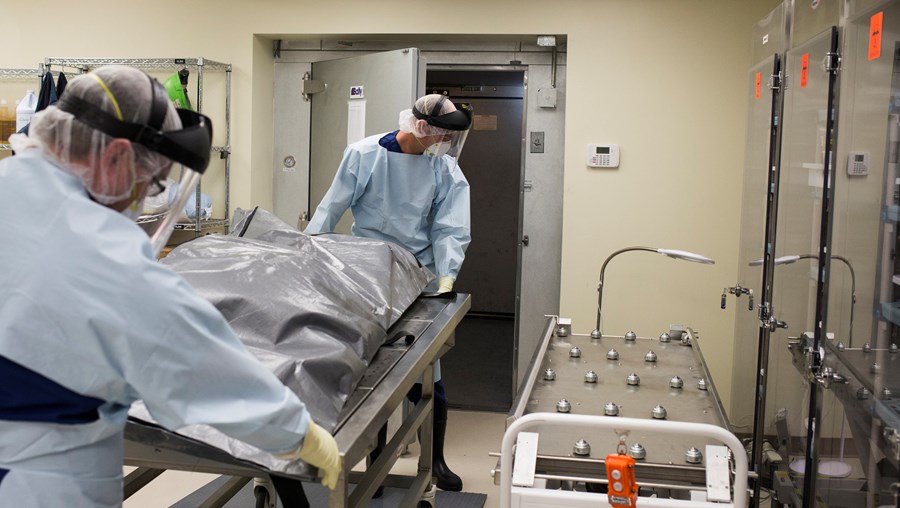Trabalhadores de um hospital transferem um cadáver para a morgue