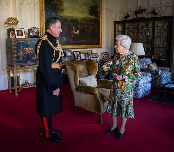 Rainha Isabel II vista em pé e a sorrir no Castelo de Windsor em Inglaterra