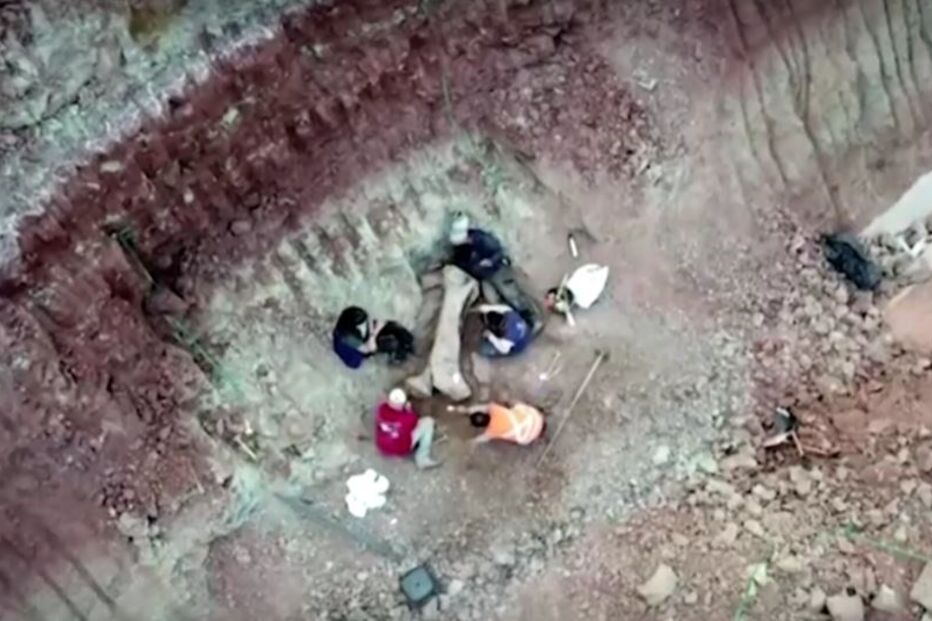 Paleontólogos da Universidade Federal de Santa Maria posam para foto ao lado de osso de dinossauro gigante encontrado em Divinópolis, estado do Maranhão, Brasil