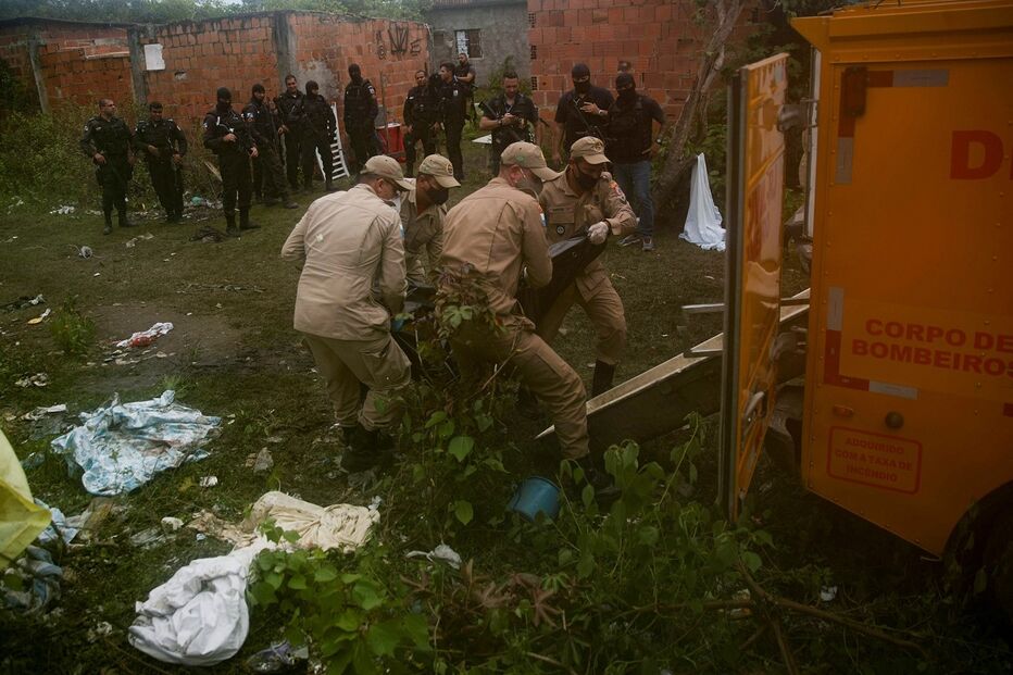 Polícias assistem à remoção dos corpos, encontrados um dia após à operação