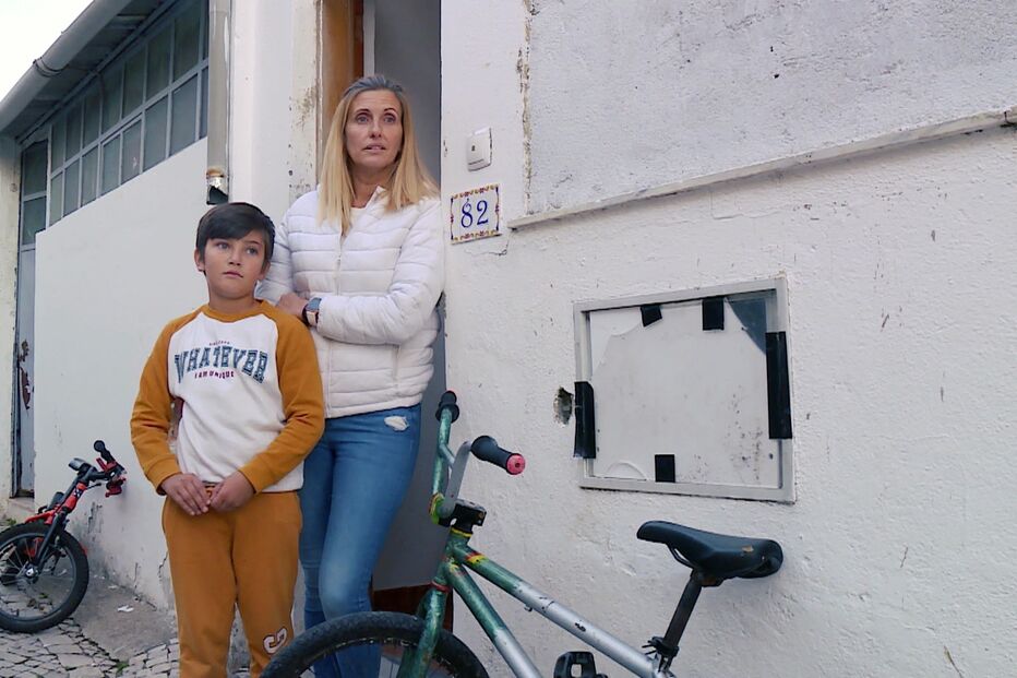 Carla Pires com o filho mais novo, Salvador, junto à casa que ocuparam