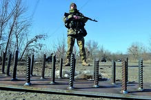 À espera.  Um militar ucraniano mantém guarda num posto perto de Kharkiv. à sua frente, uma estrutura antitanque.