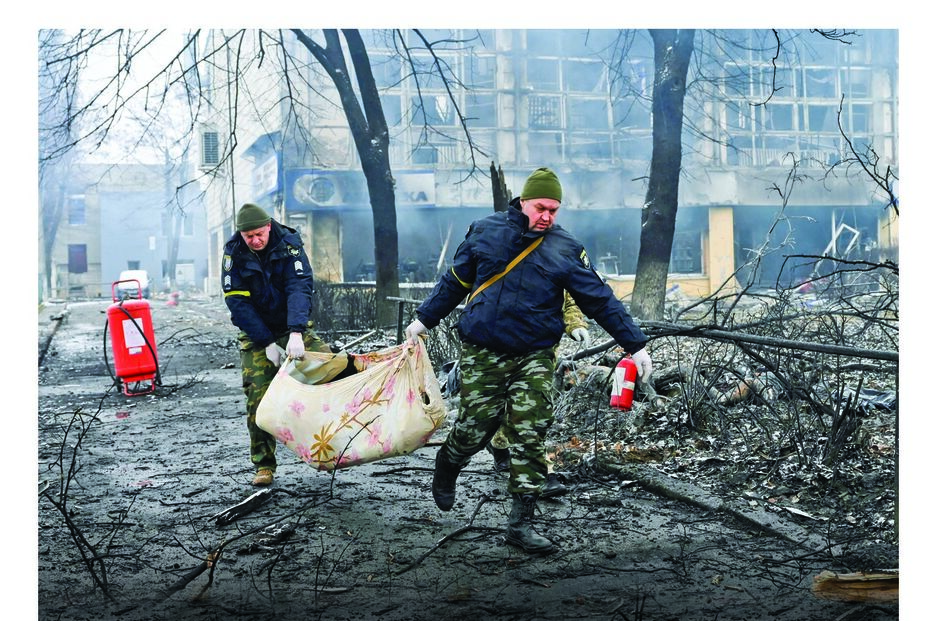 Elementos das forças de defesa civil ucraniana recolhem o corpo de uma das vítimas do ataque russo contra uma estação emissora de TV em Kiev 